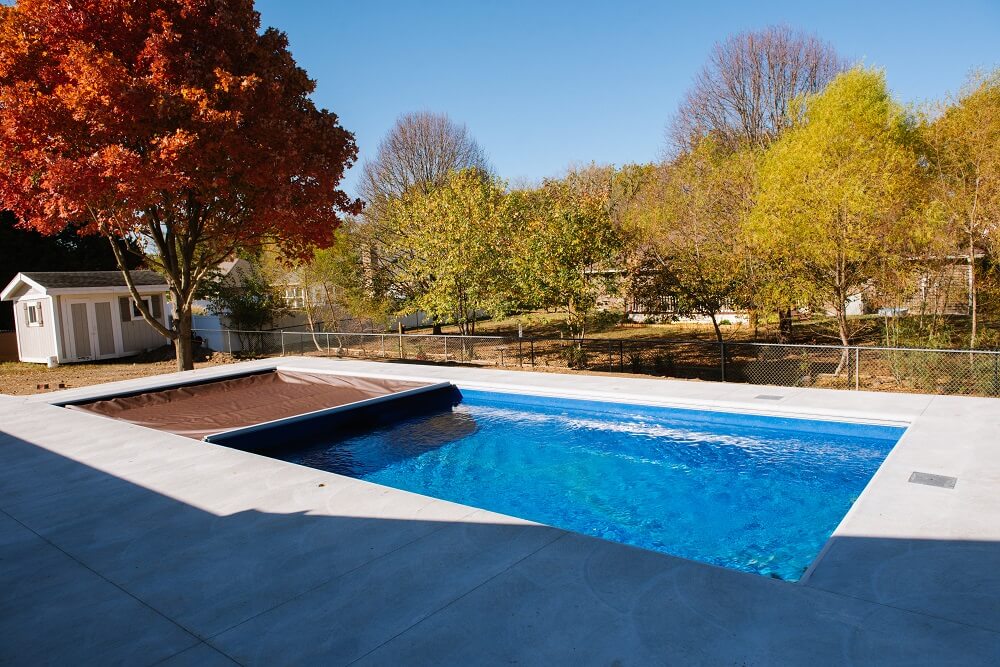 Brown automatic pool cover with fall background