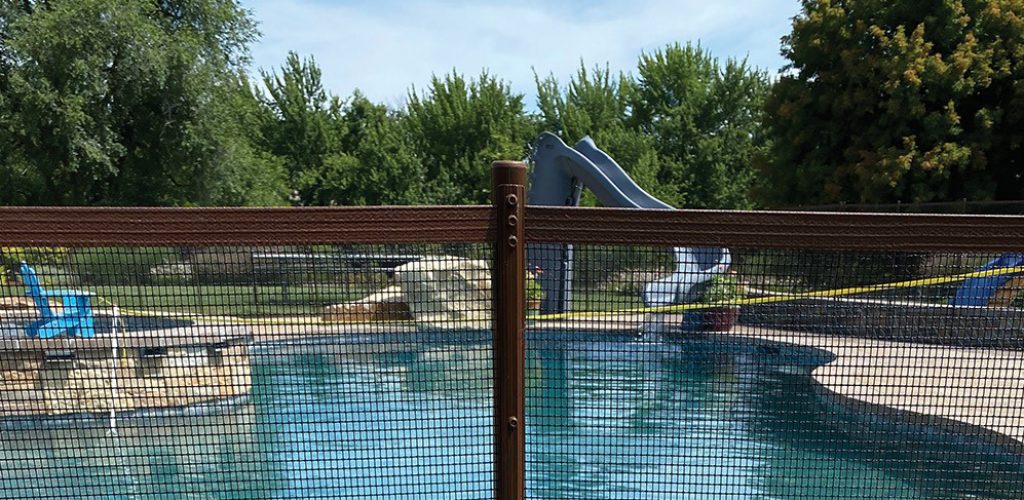 Brown mesh fence surrounding pool